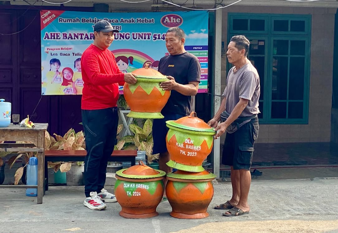 Andrian igong memberikan bantuan tempat sampah ke pengurus pasar pagi Risyanto (Atok) dna Durmi, Minggu, (27/9/2026).
